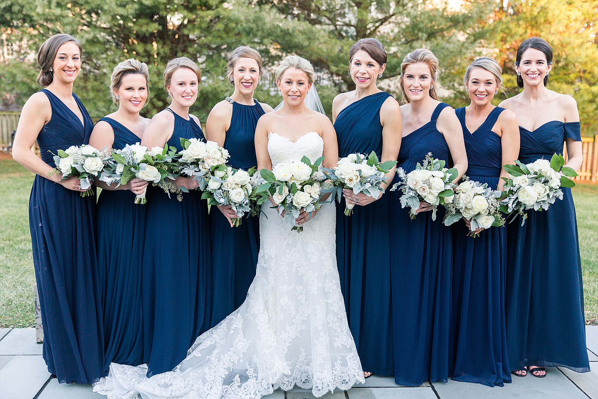 bridesmaids in navy gowns with ivory florals photographed by Alexandra Mandato Photography