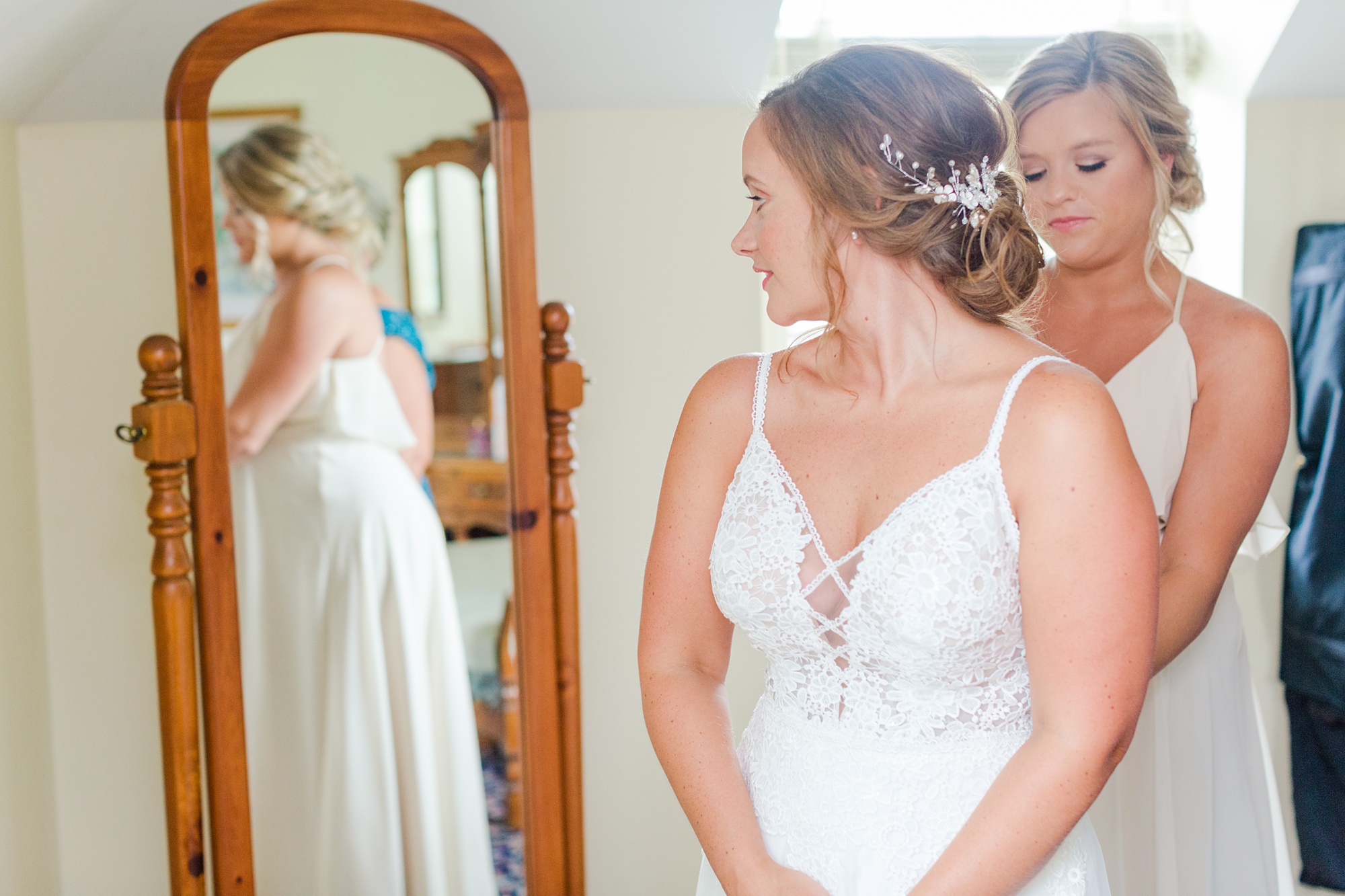 bridesmaid helps bride with gown during PA wedding day prep