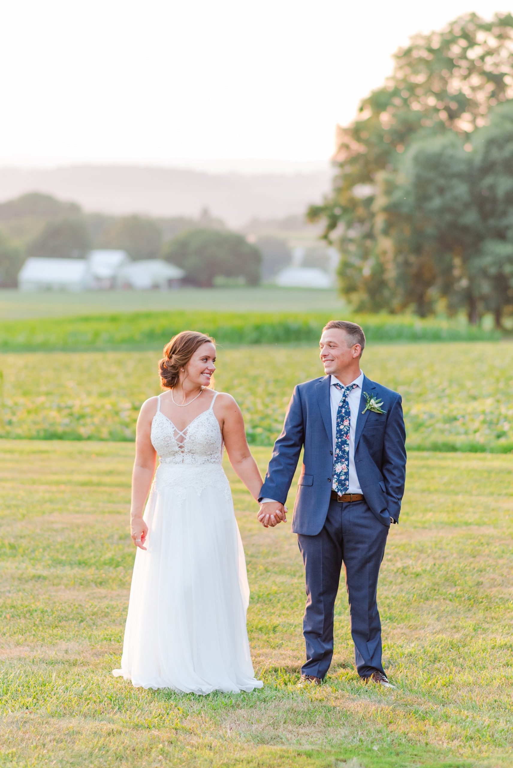 bride and groom pose in field at Drumore Estate
