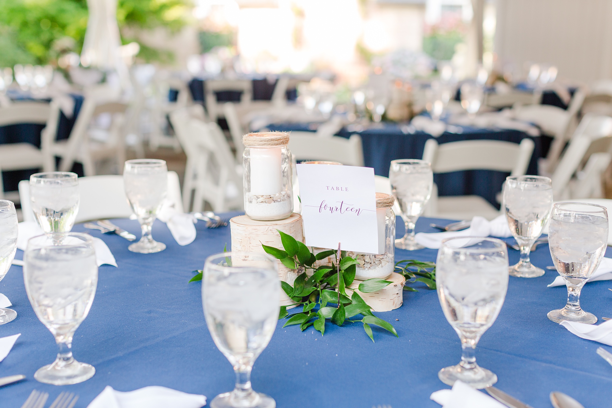 wedding reception with navy table cloths and rustic centerpieces 