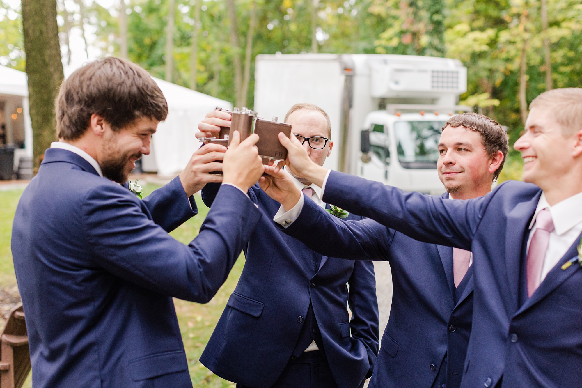 groomsmen toast with flasks before Historic Shady Lane wedding