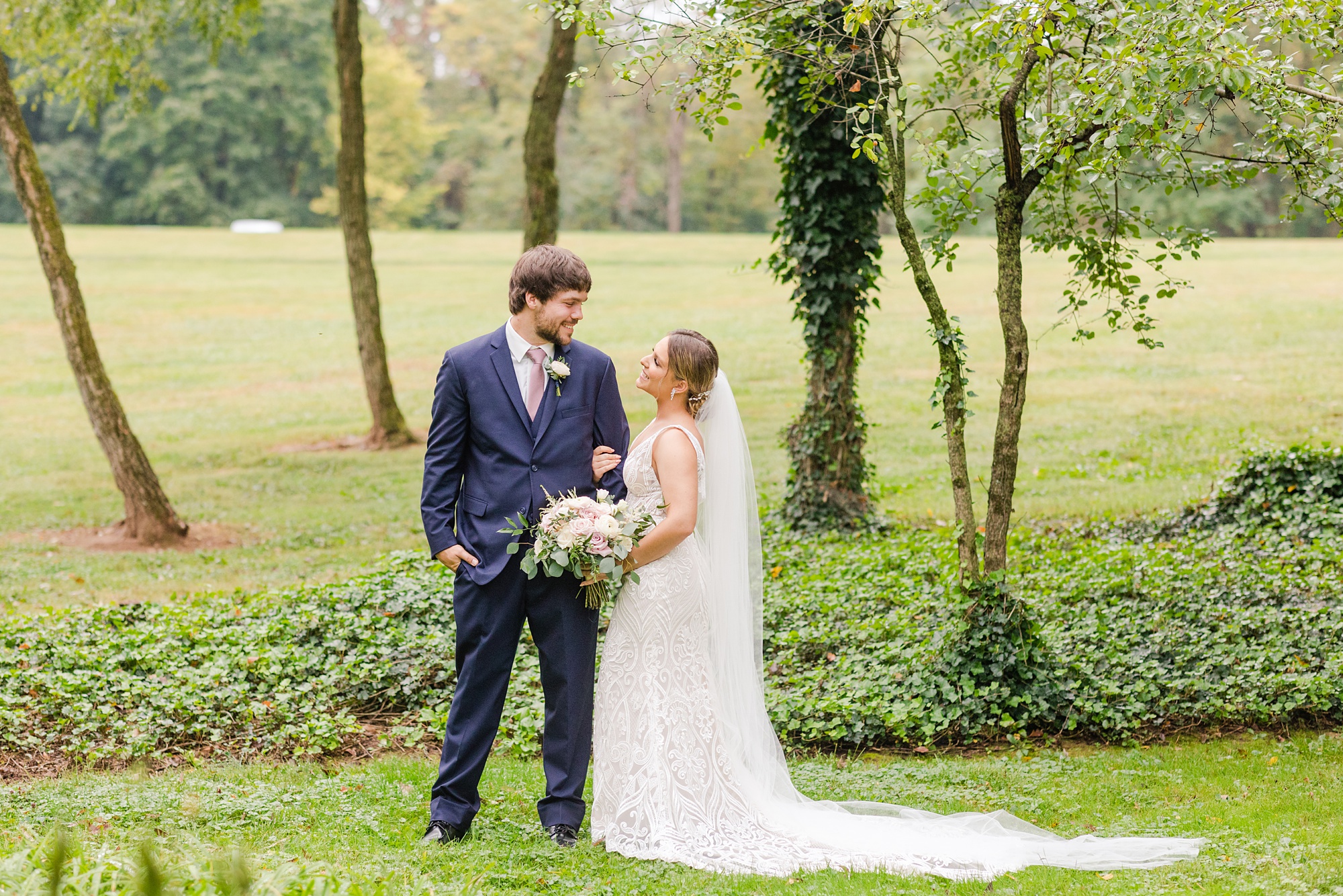 newlyweds pose alongside ivy covered trees at Historic Shady Lane