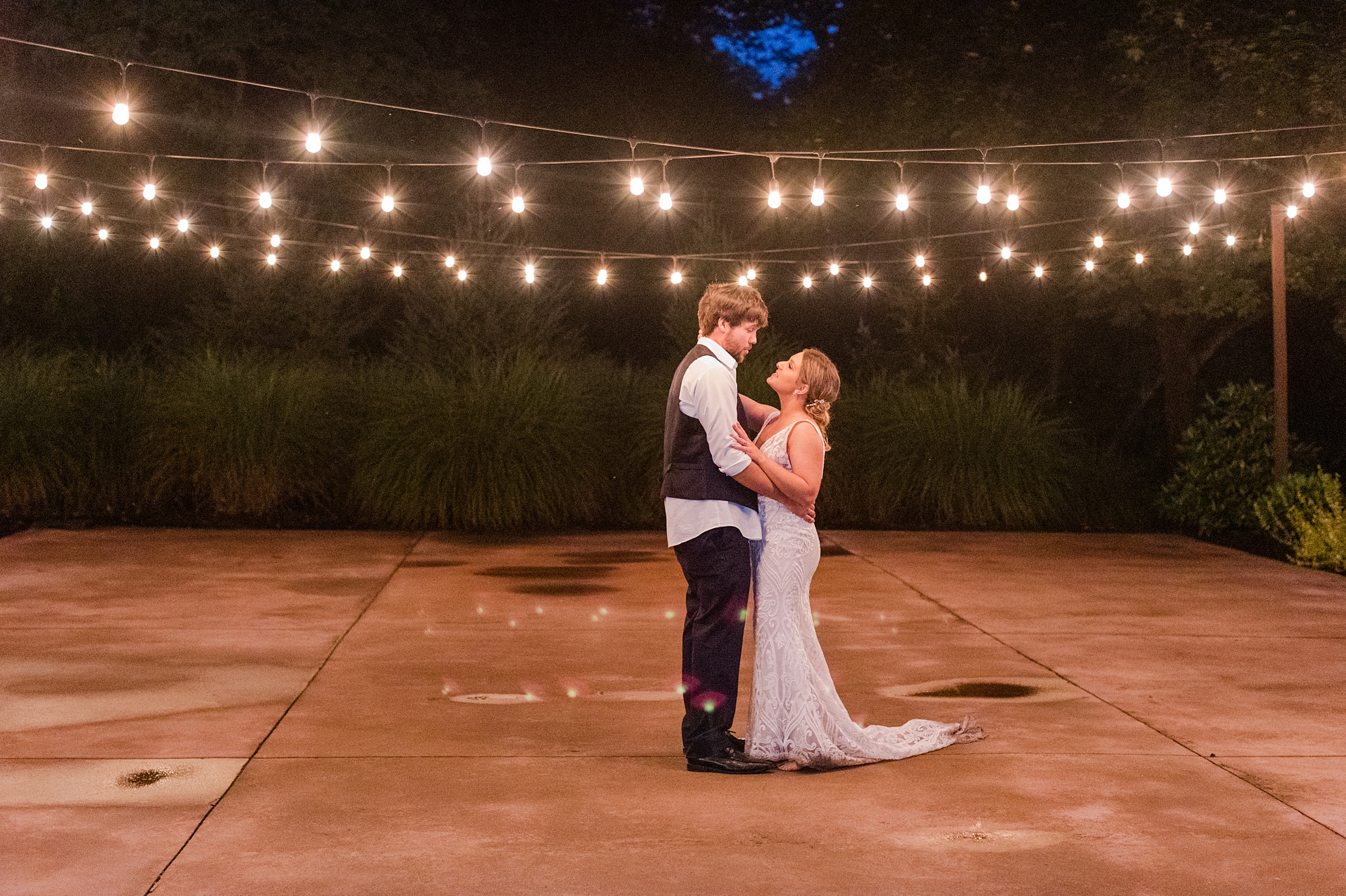 newlyweds dance under patio lights at Historic Shady Lane