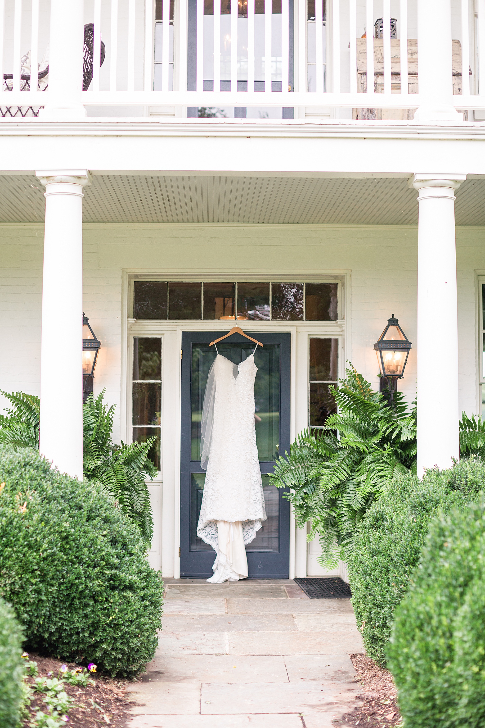 wedding dress hangs on front porch of Glen Ellen Farm photographed by Alexandra Mandato Photography