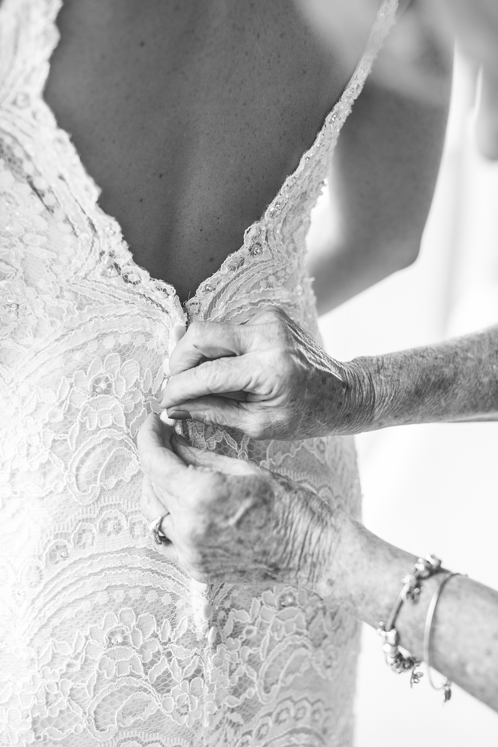 bride gets into lace wedding gown photographed by Alexandra Mandato Photography