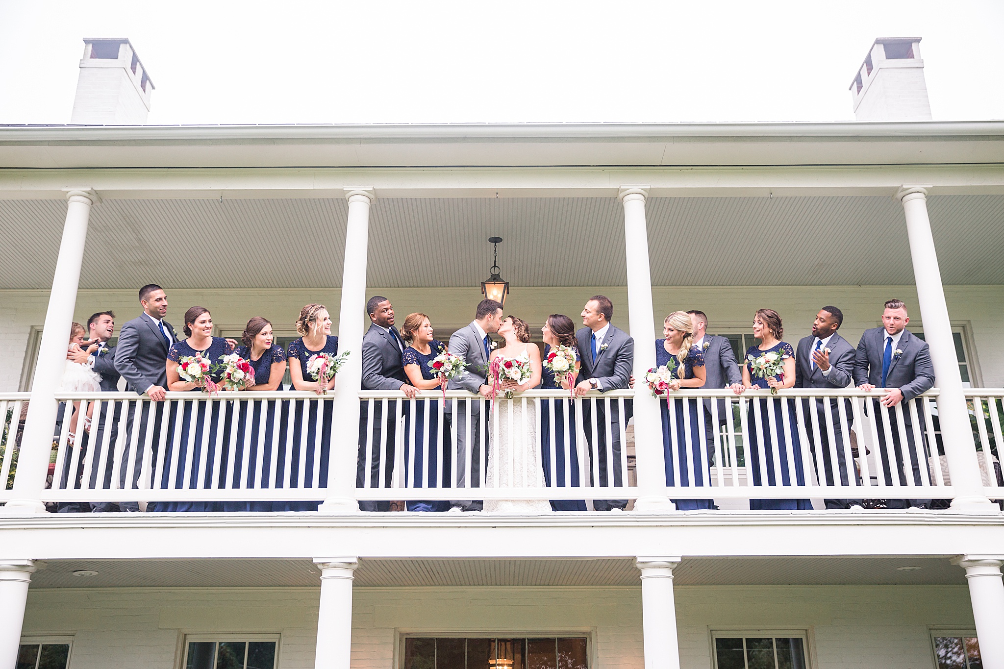 bride and groom with wedding party on balcony photographed by Alexandra Mandato Photography