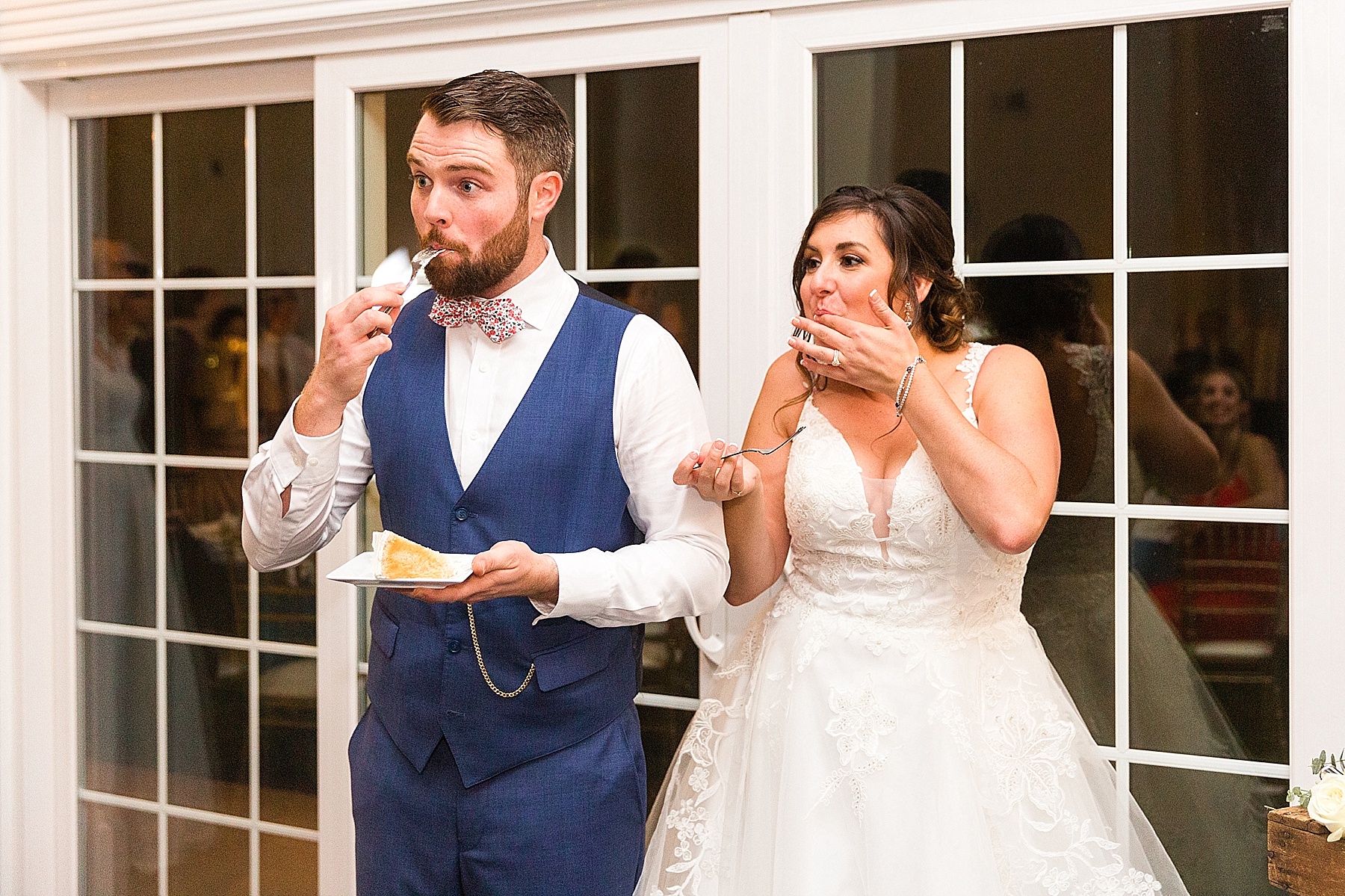 bride and groom taste wedding cake photographed by Alexandra Mandato Photography