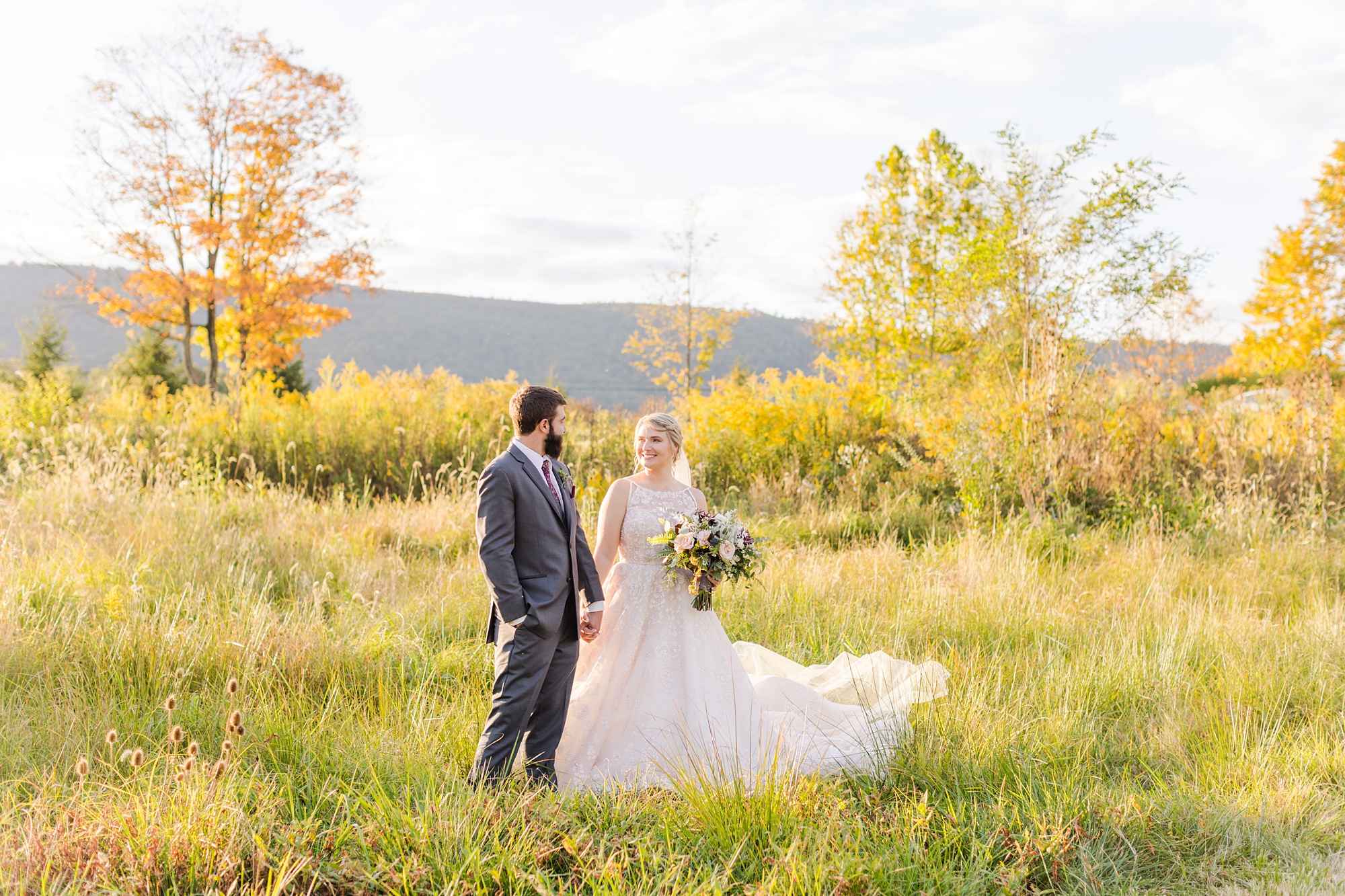 bride and groom pose in field at Iron Works House