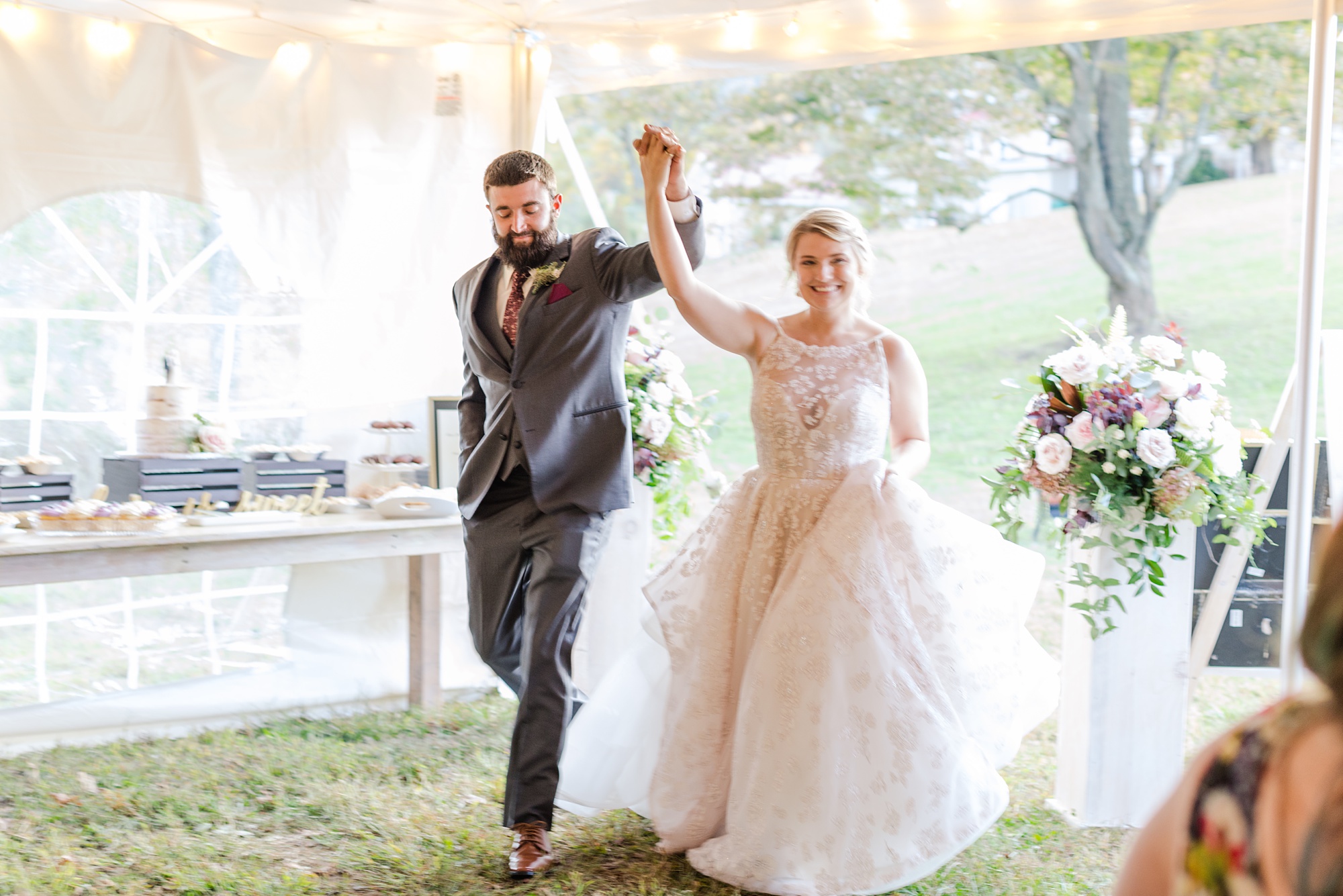 newlyweds enter fall wedding reception under tent 