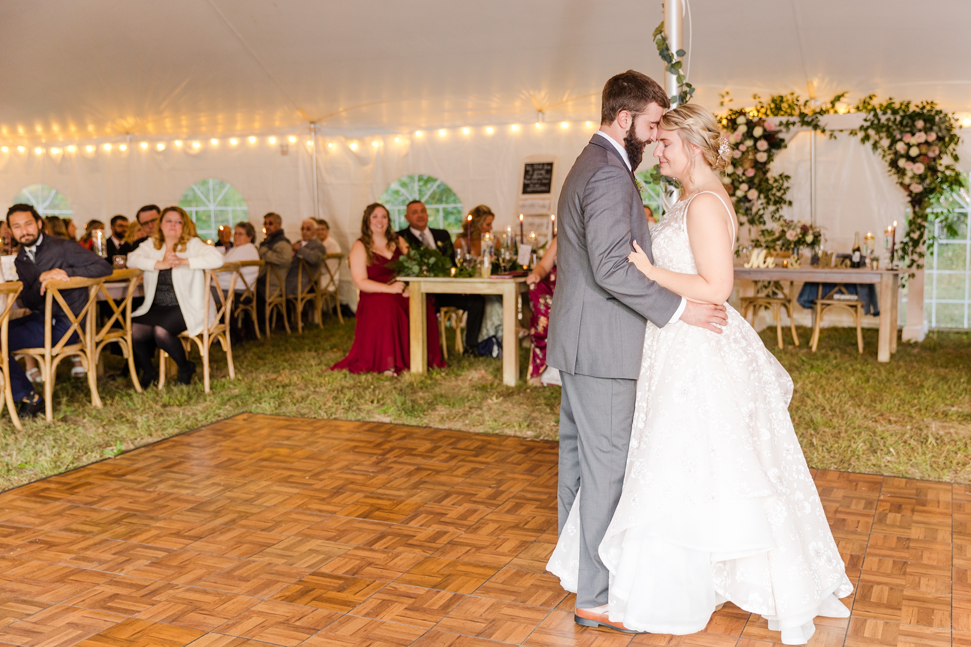 bride and groom dance together under tent